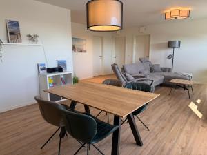 a living room with a table and a couch at Penthouse-Ferienwohnung "Tom" in Butjadingen
