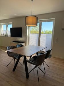 a dining table and chairs in a living room at Penthouse-Ferienwohnung "Tom" in Butjadingen +26 photos