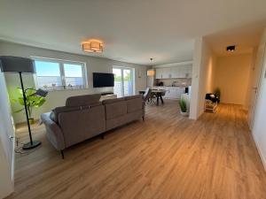 a living room with a couch and a dining room at Penthouse-Ferienwohnung "Tom" in Butjadingen