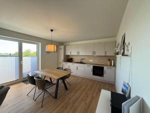 a kitchen with a wooden table and a dining room at Penthouse-Ferienwohnung "Tom" in Butjadingen