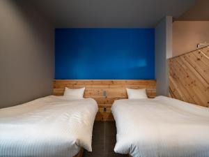 two beds in a room with a blue wall at Coteji Do - Vacation STAY 78358v in Ishigaki Island