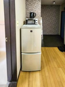 a white refrigerator with a microwave on top of it at Mamada Building - Vacation STAY 17009 in Tokyo