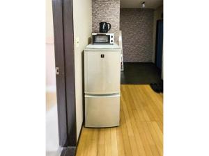 a small refrigerator with a microwave on top of it at Mamada Building - Vacation STAY 18001 in Tokyo