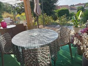 a table with chairs and an umbrella on a patio at La Naute in Saint-Paulien +12 photos