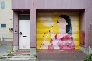 a wall with a painting of a woman holding a cigarette at Guesthouse s,e,n - Vacation STAY 99404v in Koriyama