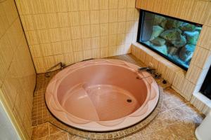 a large pink tub in a bathroom with a fishtank at Hitensanso - Vacation STAY 99438v in Azumino
