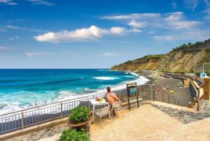 a man sitting at a table looking at the ocean at Casa con alma canaria in Los Realejos