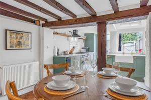 a dining room with a wooden table and chairs at Dolphin Cottage in Henley on Thames