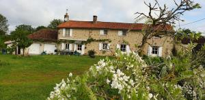 a large house in a yard with white flowers at Chambre d'hôte de Rochette in Viennay