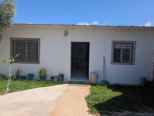 a white house with a black door and windows at Guesthouse Skhirat in Skhirat