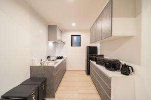 a kitchen with black and white cabinets and a sink at Yufunoshizuku -Asagiri-Yunagi-Akatsuki- - Vacation STAY 01373v in Yufuin