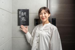 a woman standing in front of a wall at Yufunoshizuku -Asagiri-Yunagi-Akatsuki- - Vacation STAY 01373v in Yufuin +29 photos
