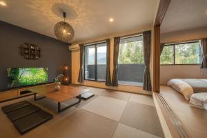 a bedroom with a bed and a table and windows at Yufunoshizuku -Asagiri-Yunagi-Akatsuki- - Vacation STAY 01489v in Yufuin