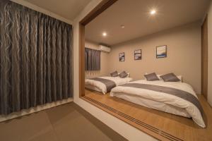 a bedroom with two beds and a large mirror at Yufunoshizuku -Asagiri-Yunagi-Akatsuki- - Vacation STAY 01489v in Yufuin