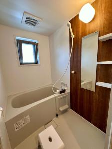 a bathroom with a tub and a toilet and a sink at Kin-Con-Kan - Vacation STAY 05378v in Nanjo +12 photos