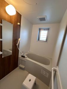 a bathroom with a bath tub and a sink at Kin-Con-Kan - Vacation STAY 03032v in Nanjo
