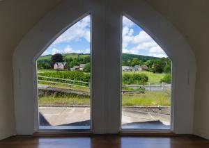 an arched window with a view of a field at Station Cottage in Bucknell