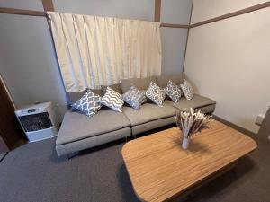 ein Wohnzimmer mit einem Sofa mit Kissen und einem Tisch in der Unterkunft Hinode Land - Vacation STAY 06589v in Kombu