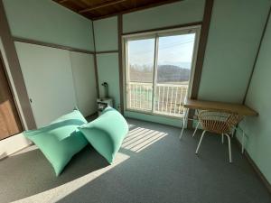 ein Zimmer mit einem grünen Kissen und einem Fenster in der Unterkunft Hinode Land - Vacation STAY 06589v in Kombu