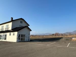 ein weißes Gebäude auf einem Parkplatz in der Unterkunft Hinode Land - Vacation STAY 06589v in Kombu