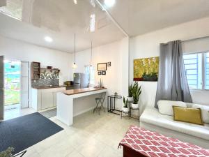 Pedro Vicente MaldonadoにあるDepartamento 2 habitaciones- Piscina, Botánico, BBQ, Terraza - THE GARDEN HOUSEのソファとテーブルのあるキッチンとリビングルーム