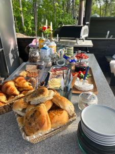 a table with bread and pastries and plates on it at Vättervy Glamping- Ravinstuga in Habo