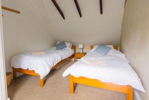 two twin beds in a room with two tables at Station Cottage in Bucknell
