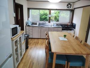 a kitchen with a wooden table with chairs and a sink at Garden-View Yufu - Vacation STAY 18616v in Yufuin +20 photos