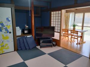 a living room with a television and a dining room table at Garden-View Yufu - Vacation STAY 18616v in Yufuin