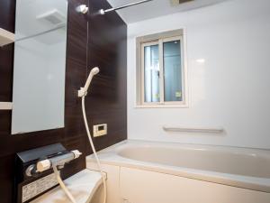 ein Bad mit einer weißen Badewanne und einem Fenster in der Unterkunft JING HOUSE Shintakasago - Vacation STAY 17117 in Tokio + 19 Fotos