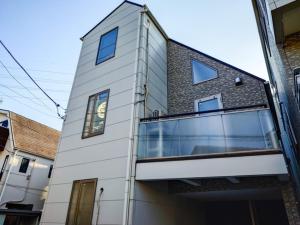 ein weißes Gebäude mit Seitenfenstern in der Unterkunft JING HOUSE Shintakasago - Vacation STAY 17117 in Tokio