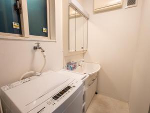 eine Küche mit Waschmaschine und Spüle in der Unterkunft JING HOUSE Shintakasago - Vacation STAY 17117 in Tokio