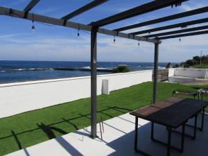 a patio with a table and a view of the ocean at Ｏｃｅａｎｓ Ｒｅｓｏｒｔ Ｖｉｌｌａ－ＦＡＲＢＥ - Vacation STAY 17105 in Shima
