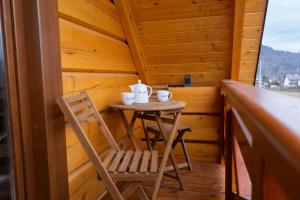 a small table and chair in the corner of a cabin at Domki z bali na miedzy in Piwniczna