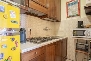 a kitchen with a stove and a yellow refrigerator at Cassina Bellavista. Vacanza perfetta in Cremeno