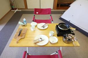 a table with plates and utensils on top of it at Ikkodaira Campsite - Vacation STAY 23092v in Daisen
