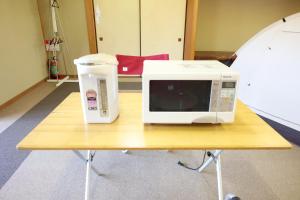 a microwave and a jug on a table at Ikkodaira Campsite - Vacation STAY 23092v in Daisen