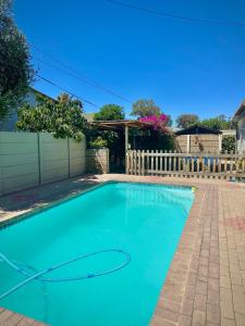 a swimming pool in a yard with a fence at Mario & Luiza's Place - Cozy Stay with Pool & Braai in Worcester
