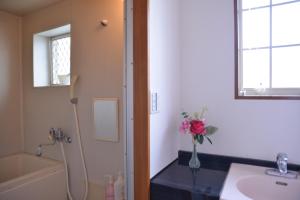 a bathroom with a sink and a vase of flowers at Green House 201 - Vacation STAY 28288v in Tokyo
