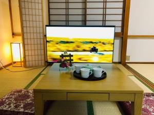 a room with a table with cups and a tv at Green House 201 - Vacation STAY 28288v in Tokyo