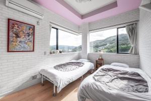 two beds in a room with a window at Momijisanso - Vacation STAY 36390v in Izu