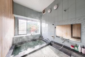 a bath tub in a bathroom with a window at Momijisanso - Vacation STAY 36390v in Izu +47 photos