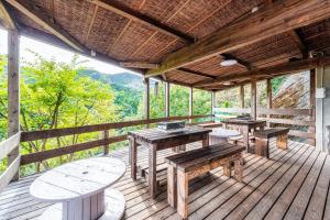 a porch with tables and benches on a wooden deck at Momijisanso - Vacation STAY 36390v in Izu