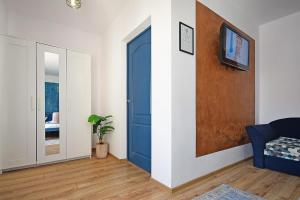 a room with a blue door and a tv on a wall at Residence by DANIA & PETRU in Târgu Ocna