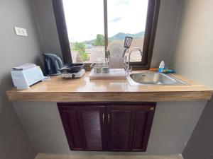 a kitchen counter with a sink and a window at Fran Sim Da Guest House in Bang Tao Beach +41 photos