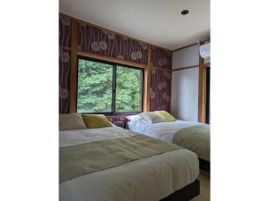 two beds in a room with a window at Shinra - Vacation STAY 29374v in Ise