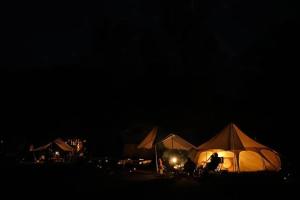 two people sitting in chairs in front of tents at night at Roots Inawashiro Lake Area - Vacation STAY 29938v in Inawashiro +8 photos