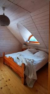 a bedroom with a wooden bed with a window at Sarni Szlak in Zawoja +45 photos