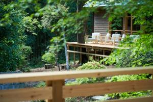 a wooden deck with white chairs and a cabin at THEIR SATOYAMA FIELD - Vacation STAY 29945v in Kurobane