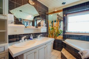 a bathroom with two sinks and a large mirror at Appartement SEPPI by MoniCare (Haus Claudia) in Seefeld in Tirol +21 photos